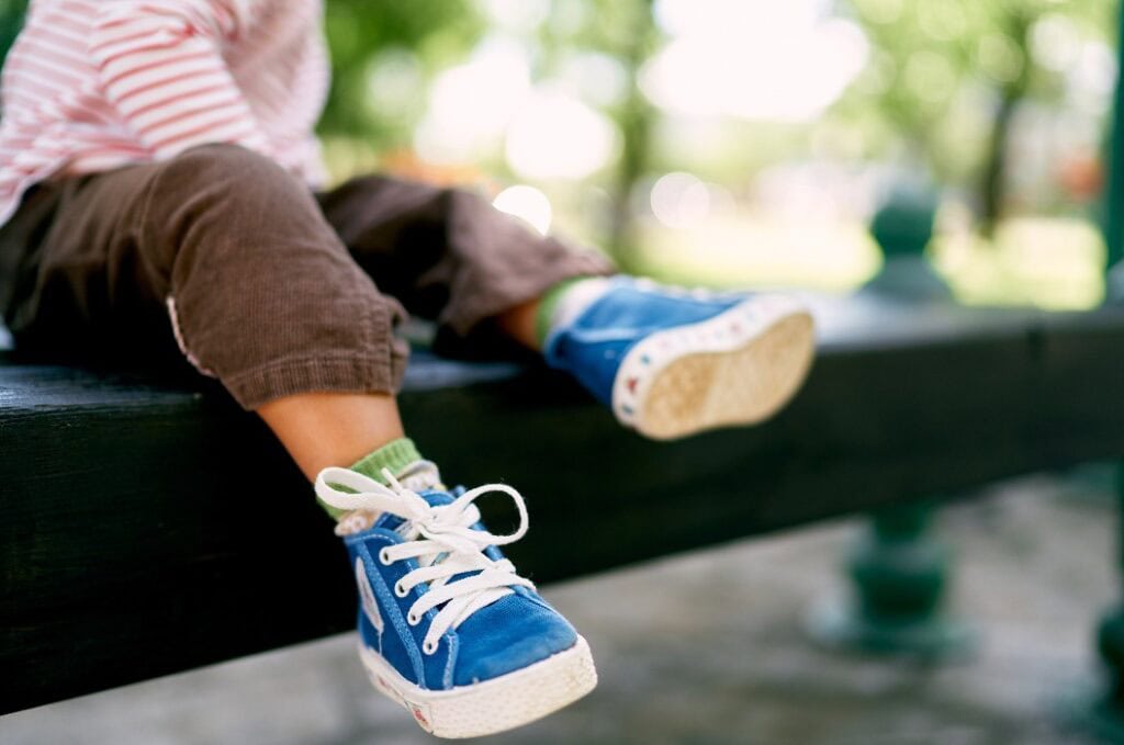 Kleine Babyfüße in blauen Turnschuhen. Nahaufnahme