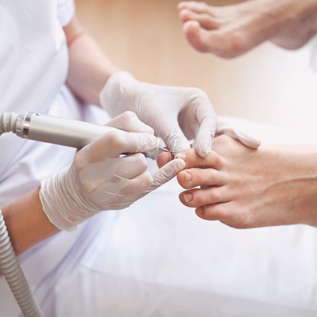 Medizinische Hardware-Pediküre mit Nagelfeilen-Bohrgerät. Patientin bei der Pediküre mit Fußpflegerin. Fußpeeling-Behandlung im Spa mit einem speziellen Gerät. Klinik für Fußpflege Podologie