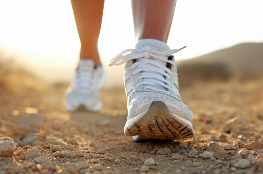 Person, die mit Wanderschuhen auf einem Wanderweg wandert